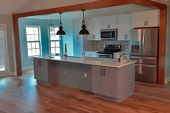 Custom kitchen design by A New Day Construction featuring a large island, upgraded countertops, modern appliances, and stylish cabinet details.