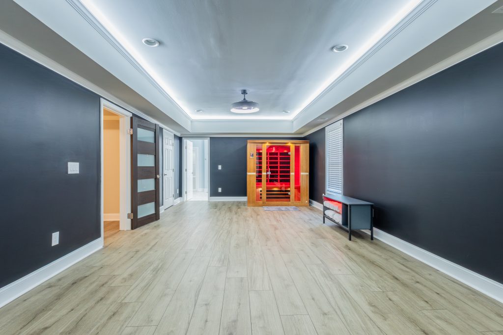 Finished basement with navy walls and infrared sauna built by A New Day Construction.
